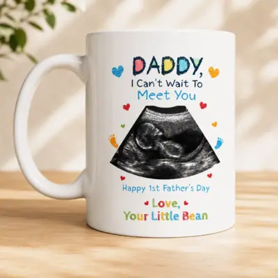 White ceramic Father's Day mug featuring a baby ultrasound photo with the colorful message "Daddy, I Can't Wait To Meet You" presented in a kraft gift box with ribbon, making a thoughtful pregnancy announcement and first Father's Day gift.