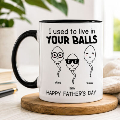 Lifestyle mockup of a personalized black handle Father's Day mug featuring the funny quote "I Used to Live in Your Balls" with custom children's names and customizable number of child illustrations.